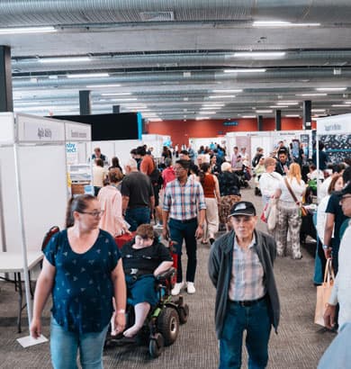 Exhibitor demonstrating mobility equipment to expo attendees